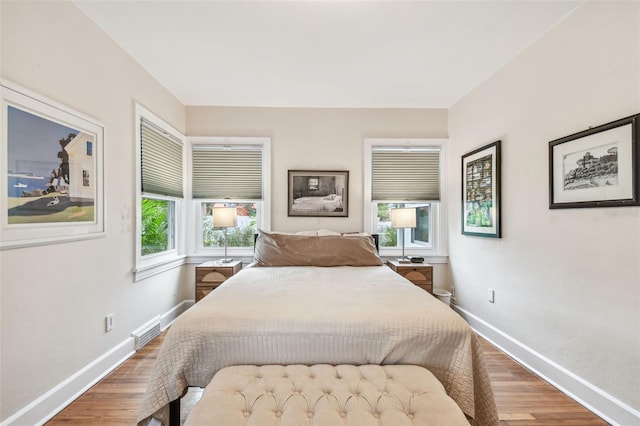 bedroom with baseboards and wood finished floors