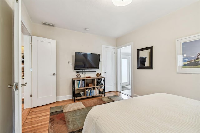 bedroom featuring light wood-style floors, baseboards, and visible vents