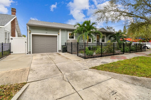 single story home with a garage, driveway, and a fenced front yard