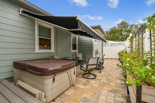 view of patio / terrace featuring a hot tub and a fenced backyard