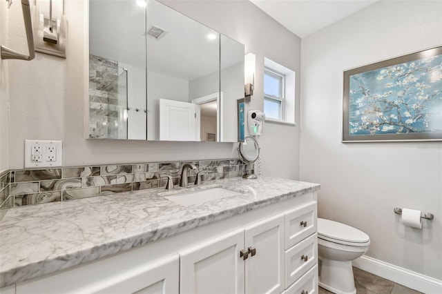 bathroom with visible vents, toilet, vanity, and baseboards