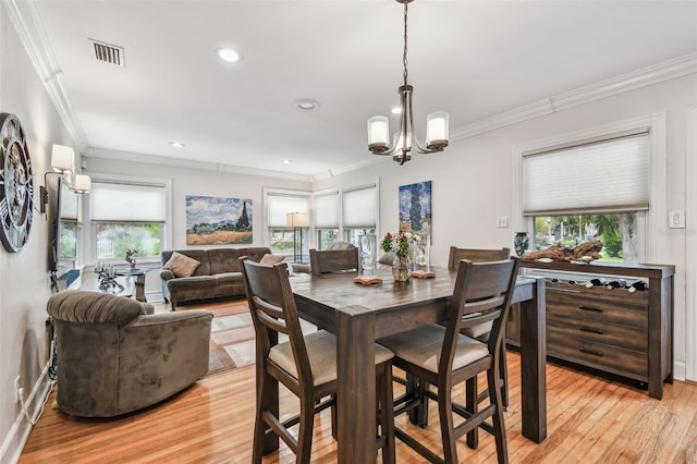 dining room with ornamental molding, visible vents, and light wood finished floors