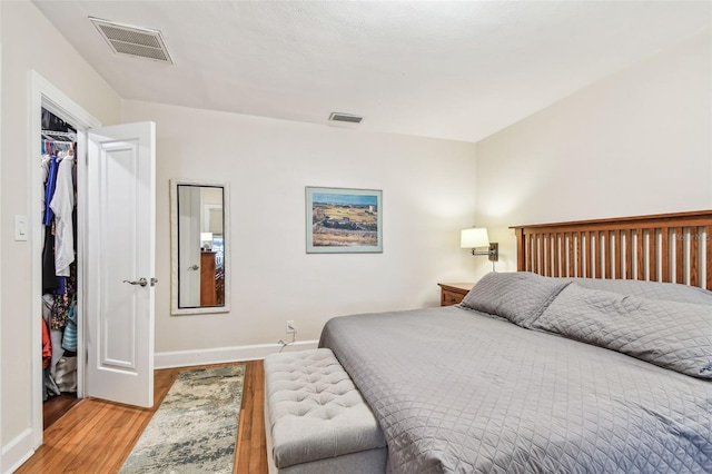 bedroom featuring wood finished floors, visible vents, and baseboards