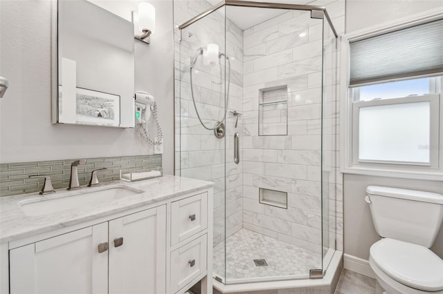 bathroom with tasteful backsplash, a stall shower, vanity, and toilet