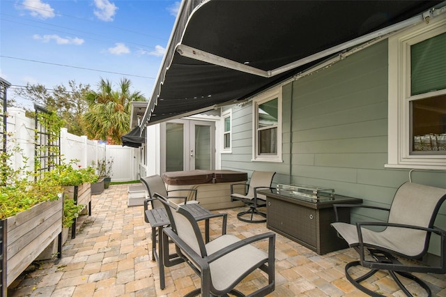 view of patio featuring french doors, a fenced backyard, and a hot tub