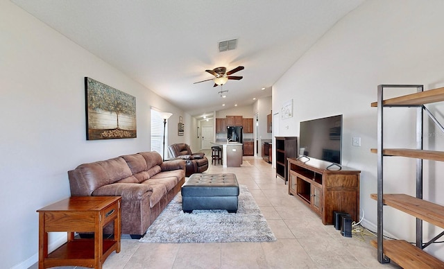 tiled living room featuring ceiling fan and vaulted ceiling