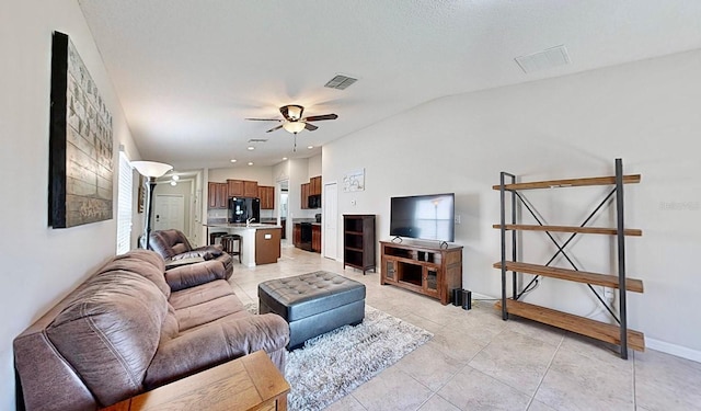 living room with vaulted ceiling, ceiling fan, and light tile patterned flooring