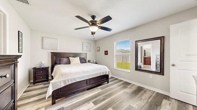 bedroom featuring ceiling fan, light wood-type flooring, and a textured ceiling