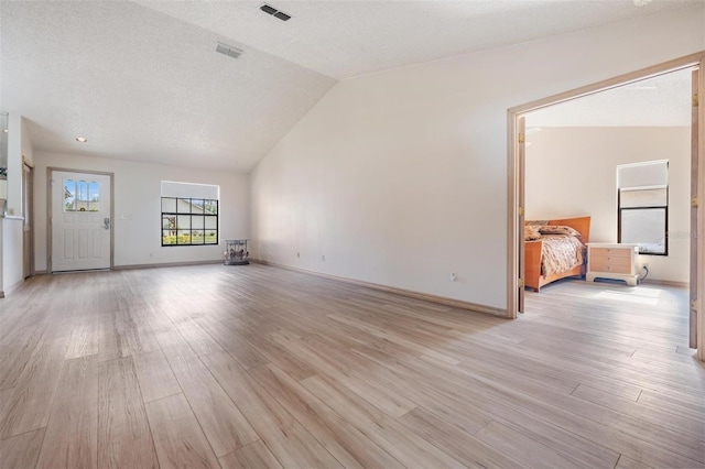 unfurnished living room featuring light hardwood / wood-style flooring and vaulted ceiling