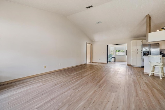 unfurnished living room with high vaulted ceiling and light hardwood / wood-style flooring