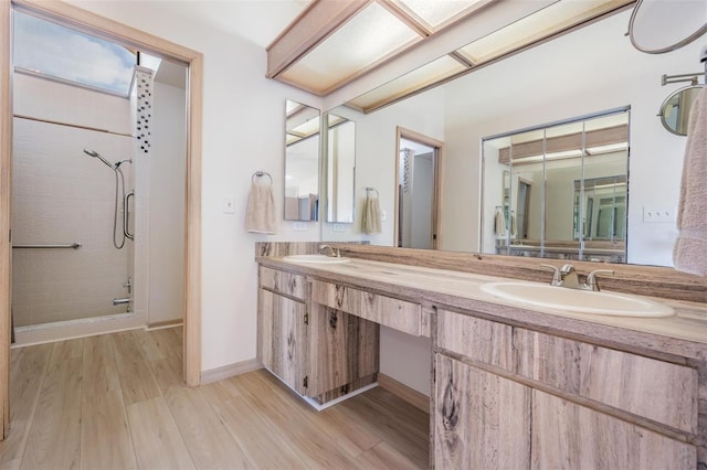 bathroom featuring hardwood / wood-style flooring, walk in shower, and vanity