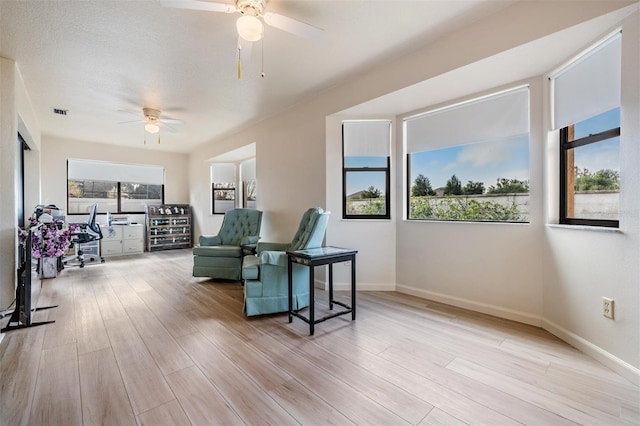 living area featuring ceiling fan and light hardwood / wood-style floors