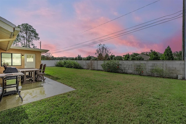 yard at dusk featuring a patio area