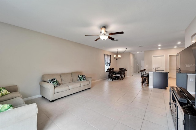 living room with light tile patterned floors and ceiling fan with notable chandelier