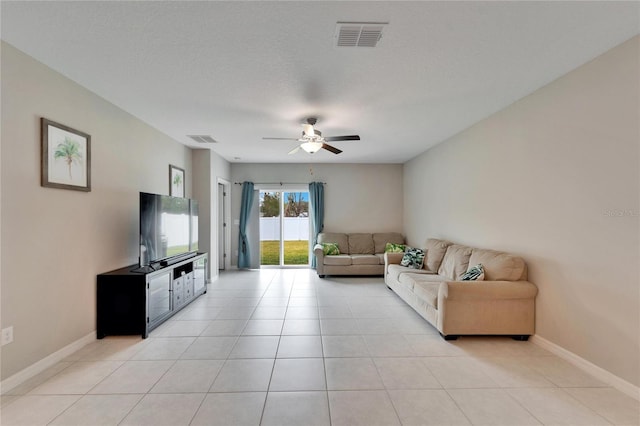 tiled living room featuring ceiling fan and a textured ceiling