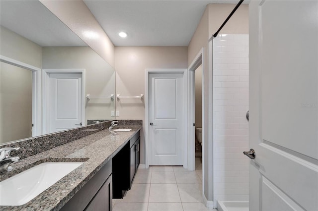 bathroom with tile patterned flooring, vanity, toilet, and a shower