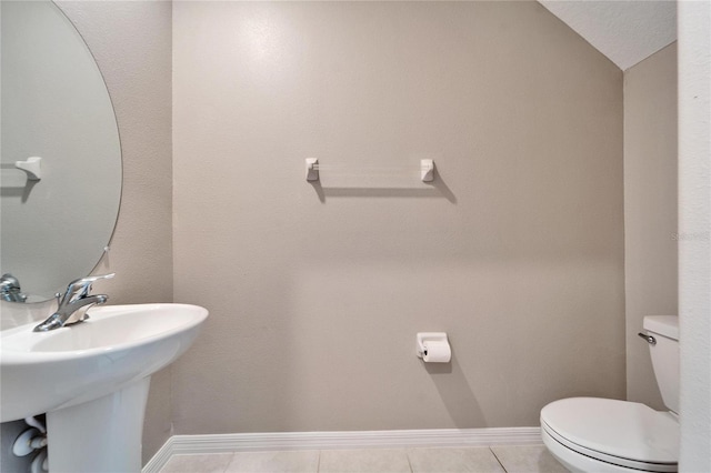 bathroom featuring tile patterned flooring, toilet, lofted ceiling, and sink