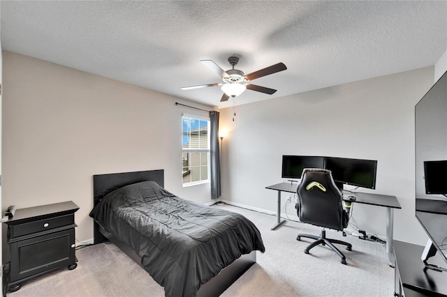 bedroom with a textured ceiling, light colored carpet, and ceiling fan