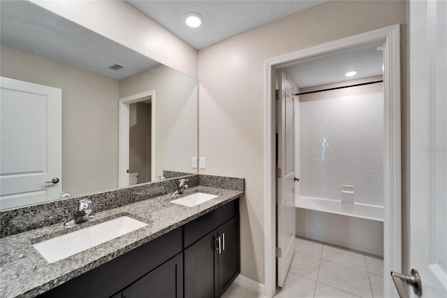 bathroom with tile patterned flooring, vanity, tub / shower combination, and a textured ceiling