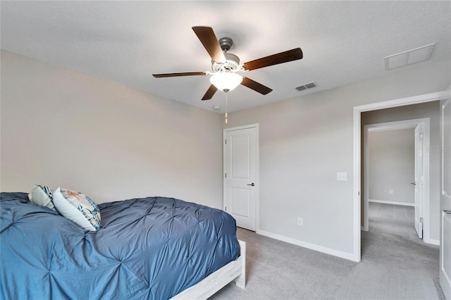 carpeted bedroom with ceiling fan and a textured ceiling