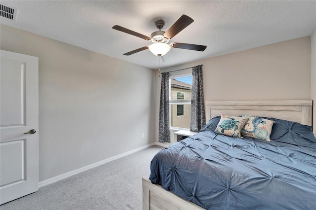 bedroom with carpet, a textured ceiling, and ceiling fan