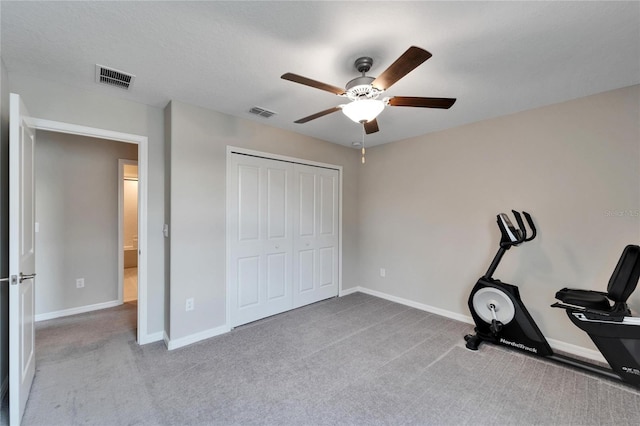 workout room featuring light carpet and ceiling fan