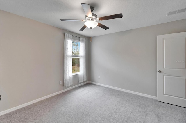 carpeted spare room with ceiling fan