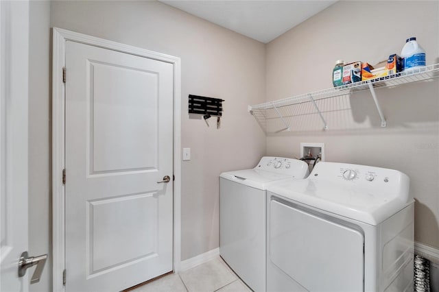 laundry room with washer and dryer and light tile patterned floors