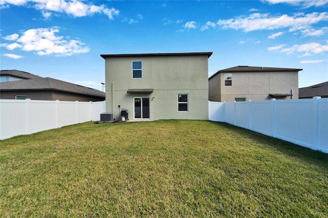 back of property featuring cooling unit and a yard