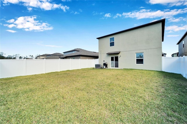 rear view of property with a yard and cooling unit