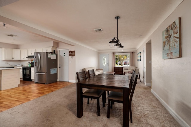 dining area featuring light carpet