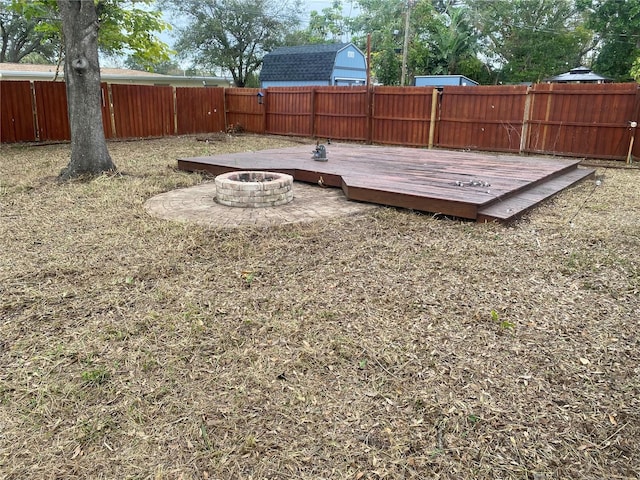 view of yard featuring an outdoor fire pit and a wooden deck