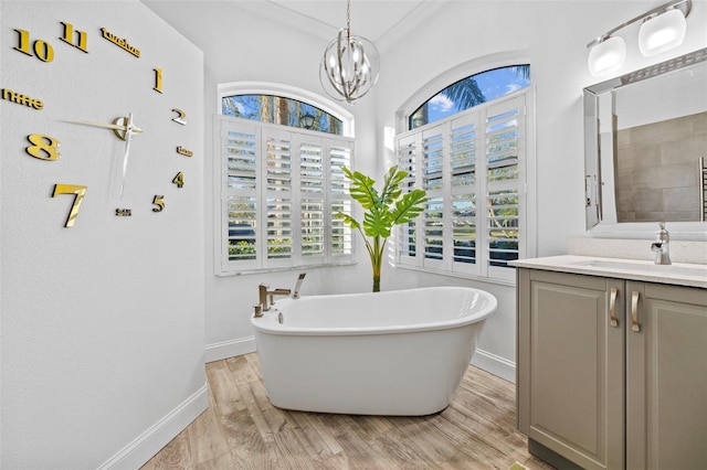 bathroom featuring hardwood / wood-style floors, vanity, a bath, and an inviting chandelier