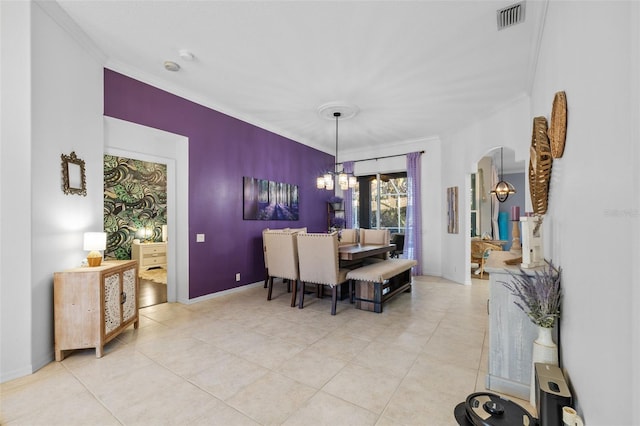 dining room with light tile patterned flooring, ornamental molding, and a chandelier