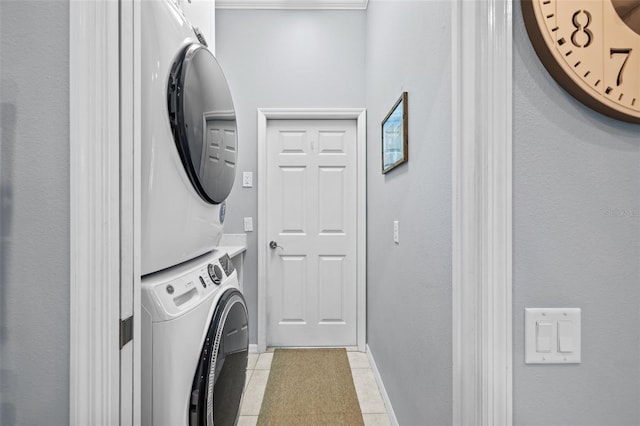 washroom featuring light tile patterned floors and stacked washing maching and dryer