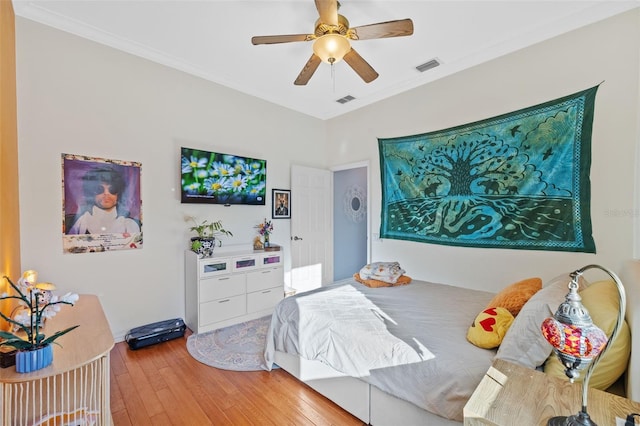 bedroom featuring ceiling fan, wood-type flooring, and ornamental molding