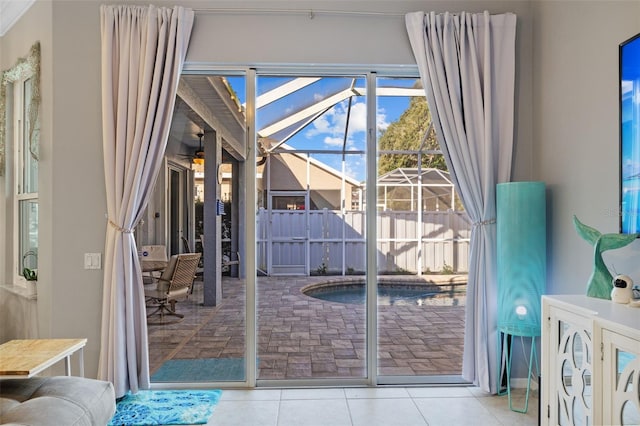 doorway featuring ceiling fan and light tile patterned flooring