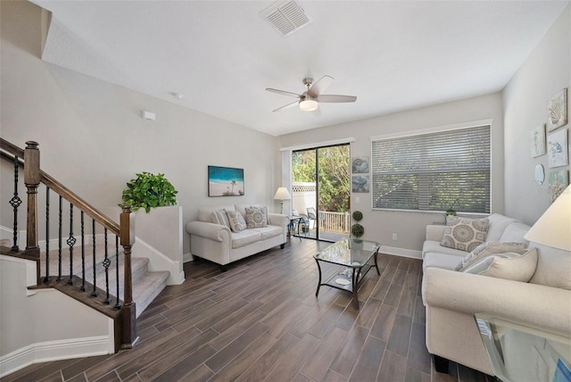 living room featuring ceiling fan and dark wood-type flooring