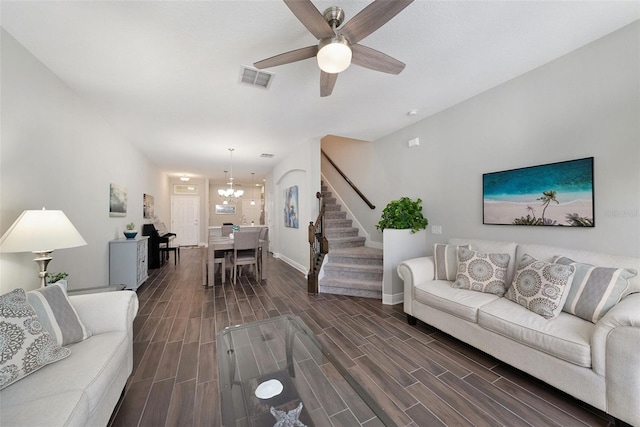 living room featuring ceiling fan with notable chandelier