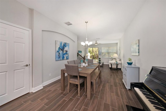 dining space with ceiling fan with notable chandelier