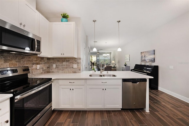 kitchen featuring white cabinetry, sink, hanging light fixtures, kitchen peninsula, and appliances with stainless steel finishes