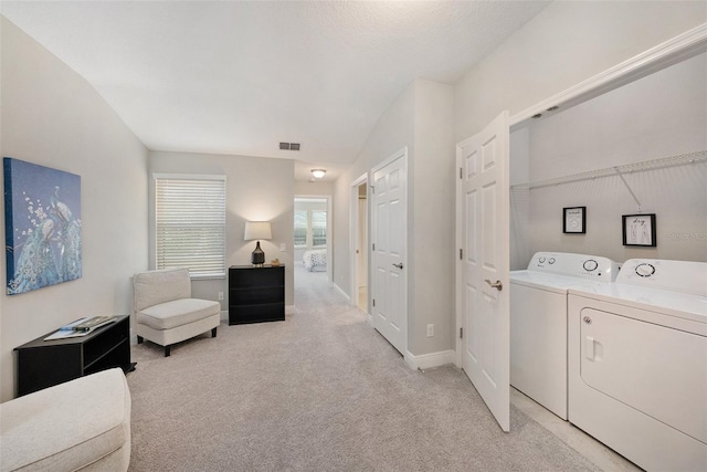 interior space with independent washer and dryer and light colored carpet