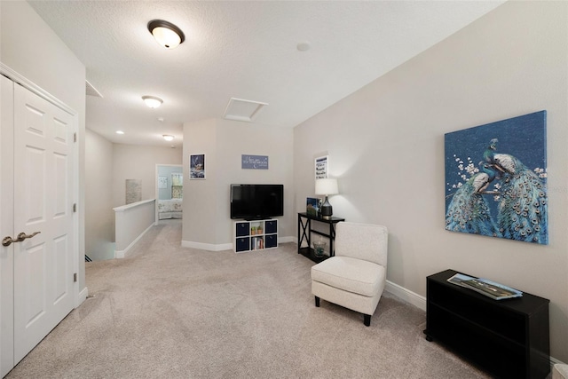 living area with light carpet and a textured ceiling