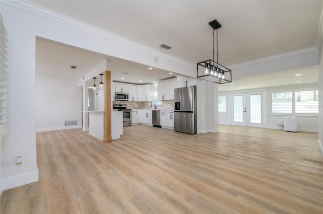 unfurnished living room featuring french doors, light hardwood / wood-style flooring, ornamental molding, and sink