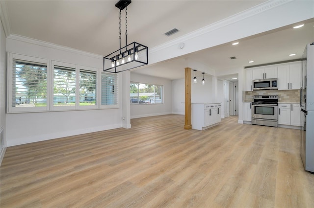 kitchen featuring pendant lighting, white cabinets, decorative backsplash, light wood-type flooring, and appliances with stainless steel finishes