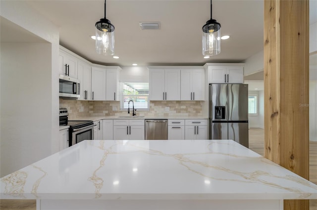 kitchen featuring sink, a center island, hanging light fixtures, and appliances with stainless steel finishes