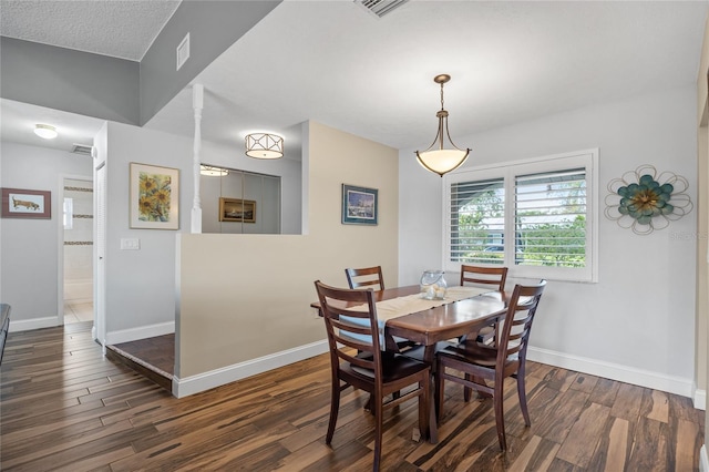 dining space with a textured ceiling and dark hardwood / wood-style flooring