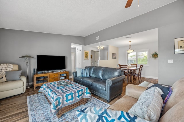 living room featuring hardwood / wood-style floors, a textured ceiling, ceiling fan, and lofted ceiling