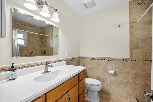 bathroom featuring toilet, vanity, tile walls, and walk in shower