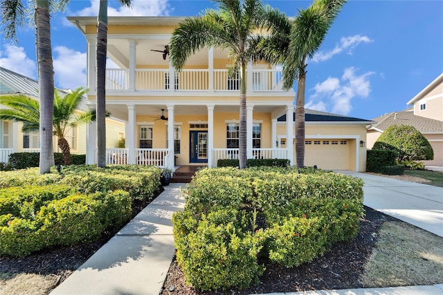 view of front facade with a porch, ceiling fan, a garage, and a balcony